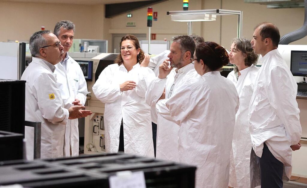 Photo de groupe durant la visite de SNEES avec le directeur de l'usine Gérald Stoger à gauche et les visiteurs à droite écoutant ses explications